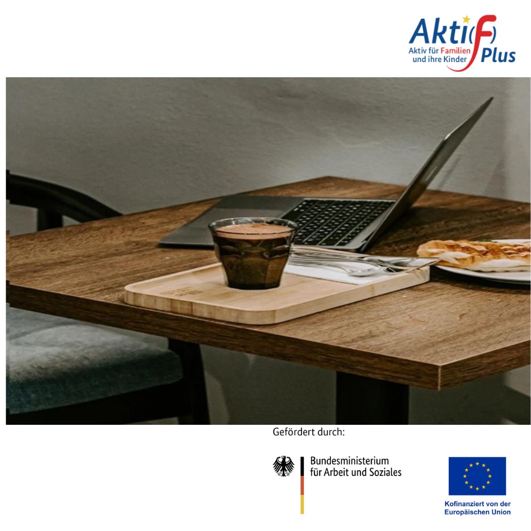 Holztisch mit Laptop, Glas mit Getränk auf Holztablett, Teller mit Gebäck, Stuhl im Hintergrund, Logo 'Aktiv für Familien und ihre Kinder' oben rechts, Förderhinweis 'Gefördert durch: Bundesministerium für Arbeit und Soziales' und EU-Flagge unten.